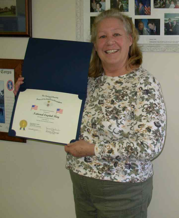 Mary Macy displays a Flag Certificate awarded by the Fairfax Resolves Chapter.