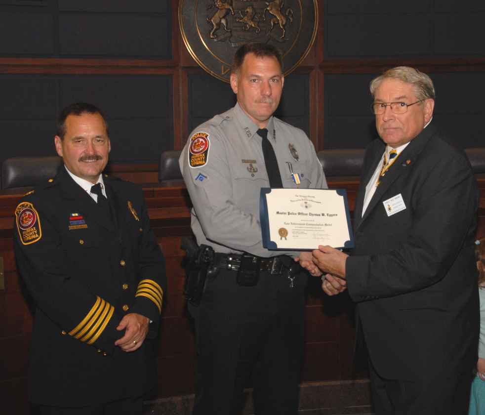 Master Police Officer Thomas W. Eggers receives the Law Enforcement Commendation Medal from President Jack Sweeney.