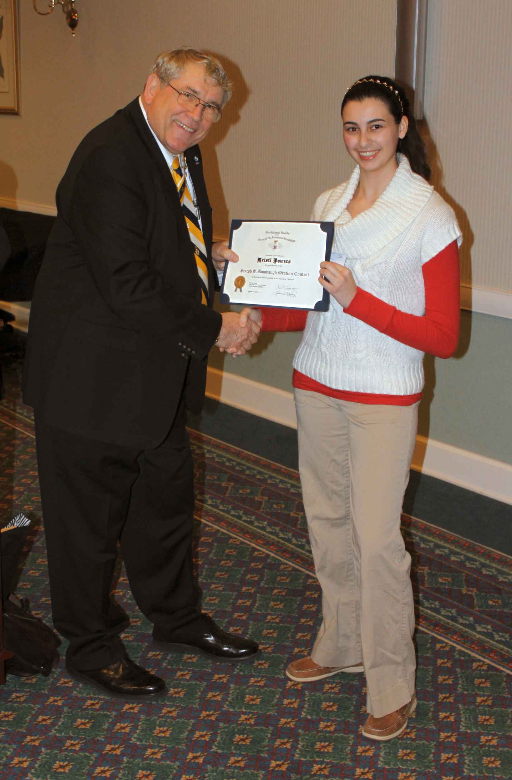 President Jack Sweeney presents the winner of the chapter oration contest, Kristi Bowers, with a check and certificate.