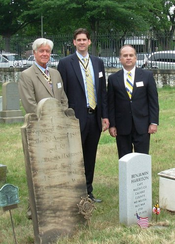 D.C. Society compatriots Duane Tackitt and Robert Warren (left) stand with Fairfax Resolves member Bill Price behind the grave markers of Patriots Elisha and Benjamin Harrison at the Congressional Cemetery in Washington, D.C.